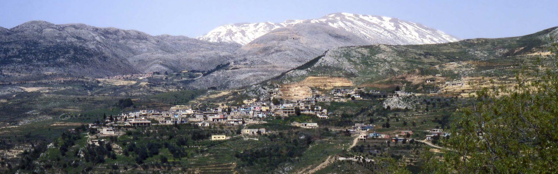 הכפר עין קיניא על רקע הר החרמון המושלג