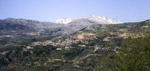 הכפר עין קיניא על רקע הר החרמון המושלג