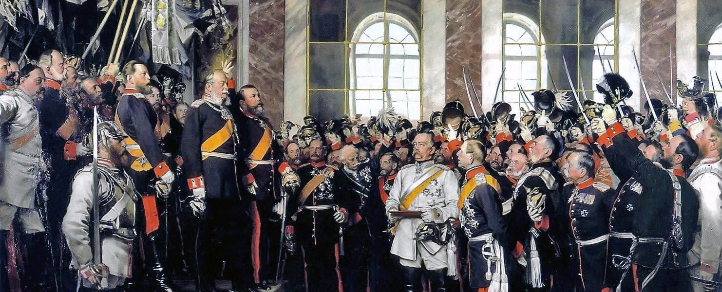 18 בינואר 1871: ההכרזה על האימפריה הגרמנית והכתרת וילהלם הראשון כקיסר גרמניה באולם המראות שבארמון ורסאי. ביסמרק במדים לבנים, והדוכס של באדן עומד ליד וילהלם. יורש העצר פרידריך, לאחר מכן פרידריך השלישי, עומד לימין אביו וילהלם. ציור של אנטון פון ורנר. באדיבות ויקימדיה CC 0.0