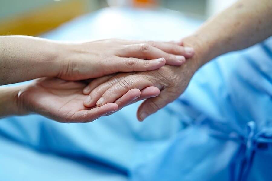 בן משפחה מחזיק יד של אדם המטופל בבית חולים, באדיבות bigstock